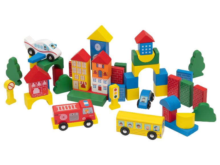 Ville jouet en bois colorée avec bâtiments, véhicules et arbres.