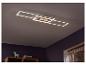Un luminaire LED moderne au plafond dans une pièce avec une étagère en bois.