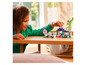Un enfant joue avec des ensembles LEGO Minecraft, notamment une maison et un cochon.