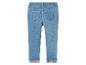 Un jean bleu pour fille avec un motif d'ours sur l'ourlet.