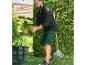 Un homme ramasse des feuilles dans le jardin avec un râteau et un sac à déchets Parkside.