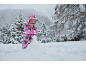 Enfant en combinaison de neige colorée jouant dans la neige, faisant un bonhomme de neige.