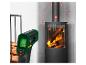 Un thermomètre mesure la température d'un foyer à bois en combustion.
