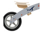 Un vélo d'apprentissage en bois avec un cadre gris et un motif de baleine bleue.