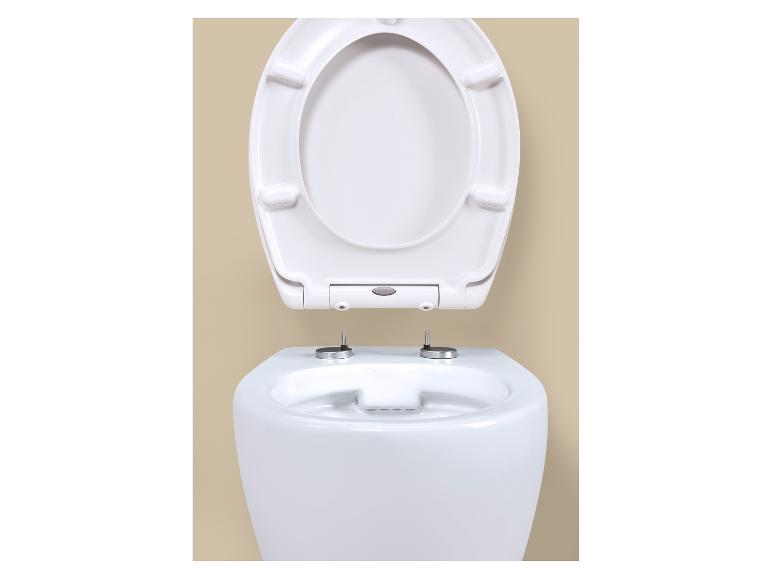 Toilettes blanches avec abattant ouvert sur fond beige