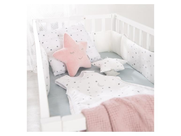 Lit bébé avec parure de lit étoilée et oreiller rose en forme d'étoile.