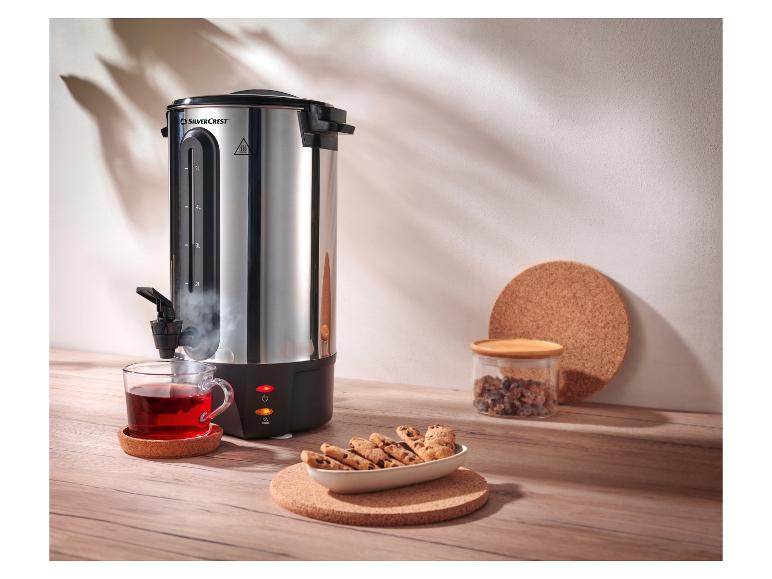 Distributeur d'eau chaude SilverCrest avec une tasse de thé et des biscuits sur une table en bois.