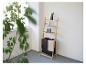 Une étagère en bois élégante avec un panier à linge, décorée de bougies et d'une plante en pot.