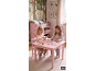 Deux filles jouent à une table rose avec des chaises, entourées de meubles et de décorations sur le thème de la forêt.