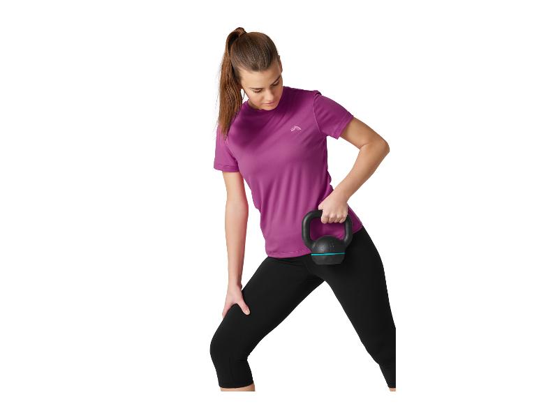 Femme en tenue de sport violette et noire, tenant une kettlebell noire.