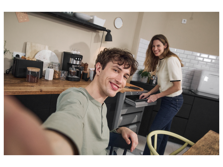 Un couple dans une cuisine moderne avec des appareils encastrés.
