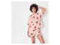 Femme en pyjama rose avec des coeurs rouges
