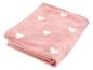 Couverture rose pliée avec des cœurs blancs
