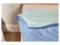 Une couette bleu clair sur un lit.