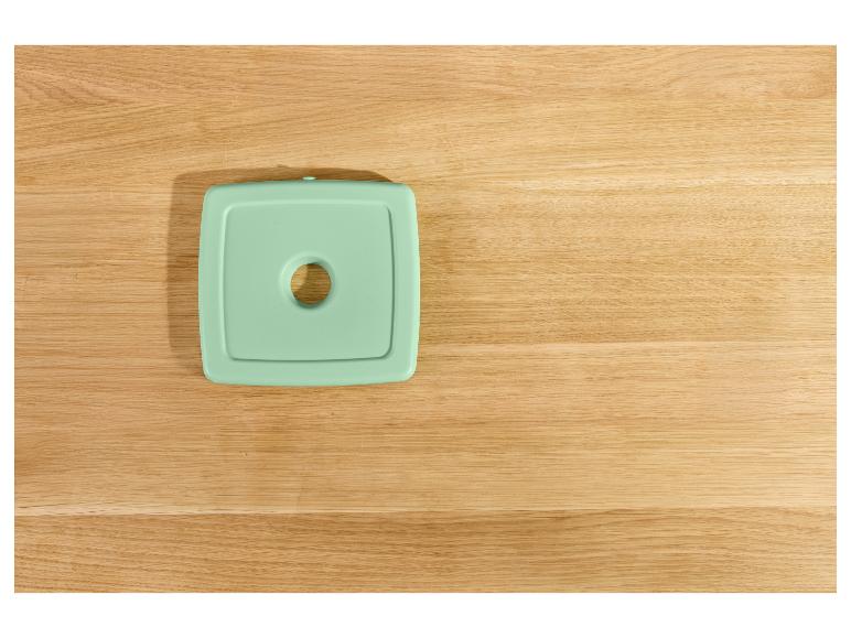 Couvercle de récipient alimentaire couleur menthe sur un comptoir en bois.