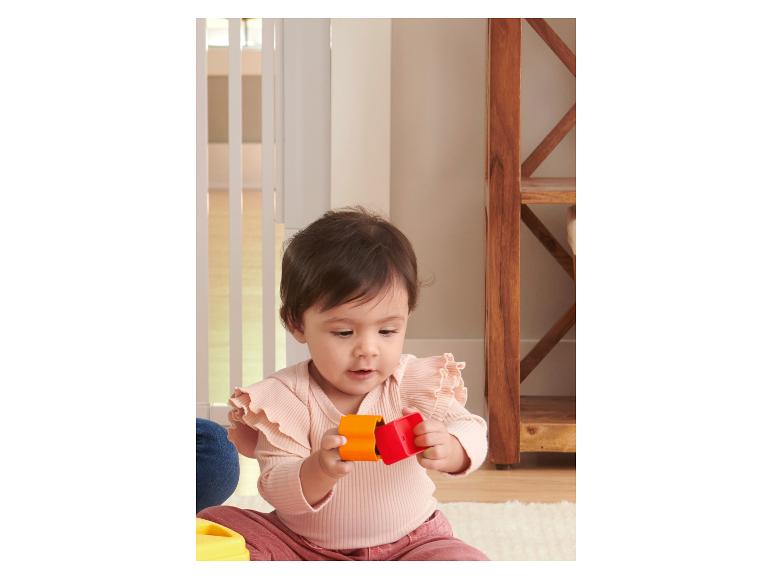 Bébé jouant avec des jouets colorés de MATTEL.