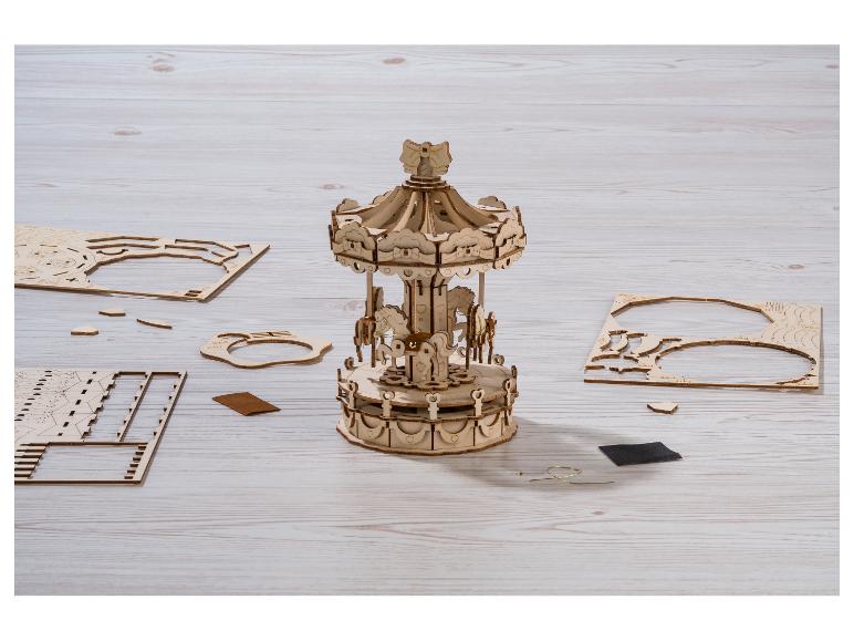 Carrousel en bois assemblé et pièces de puzzle sur une table en bois.