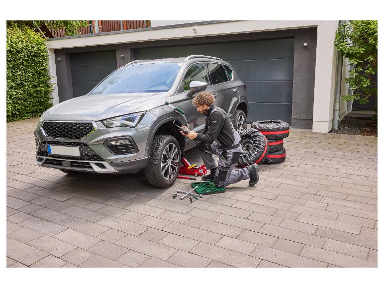Homme changeant les pneus de voiture, avec cric et clés à molette.