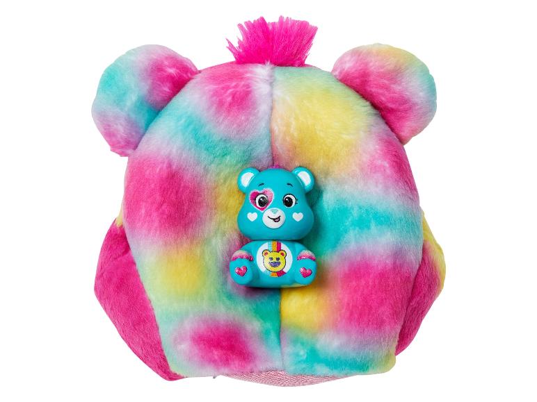 Coussin en peluche coloré avec une figurine d'ours bleu.