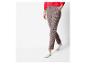 Une femme portant un pull rouge et un pantalon à carreaux.