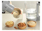 Un blender avec des flocons d'avoine, des amandes, des noix de cajou et de l'eau pour faire du lait végétal.