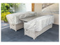 Un salon de jardin en osier avec une table et deux chaises, recouvert d'une housse de protection.