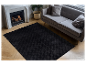 Tapis noir moelleux dans un salon moderne avec canapé gris.