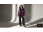 Femme en doudoune bordeaux, pull noir, pantalon large et bottines.