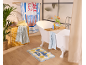 Salle de bain avec baignoire, serviettes, plante et tapis de bain avec le texte « la vie est belle ».