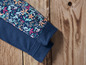 Un pantalon bleu avec un motif floral sur le bas