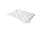 Couette blanche matelassée, pliée soigneusement sur fond blanc.