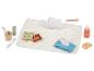 Ensemble de jeu de soins pour bébé avec thermomètre, brosses à dents et lotion.