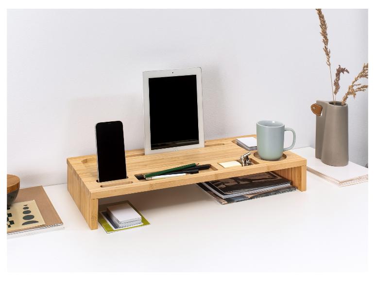 Un support pour ordinateur portable en bois avec une tablette, un téléphone et une tasse