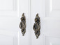 Deux portes blanches avec des boutons en laiton anciens.
