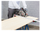 Un ouvrier utilise une scie circulaire sans fil Parkside sur une table de travail.