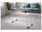 Séchoir à linge pliable dans un salon moderne avec un canapé et de la décoration.