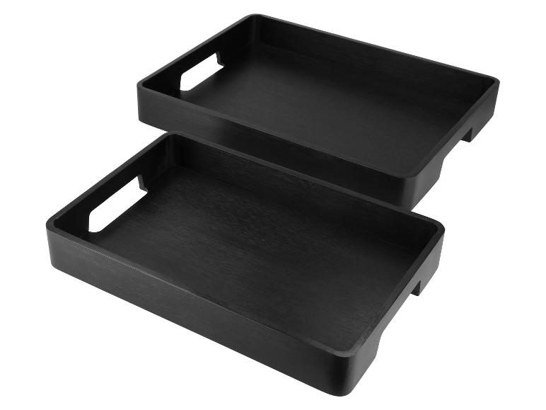 Deux plateaux de rangement noirs rectangulaires avec poignées découpées.