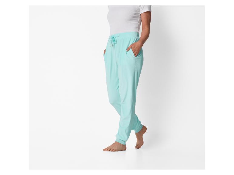 Femme en t-shirt blanc et pantalon de survêtement turquoise