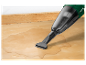 Un aspirateur Parkside nettoie de l'eau renversée sur une surface en bois.