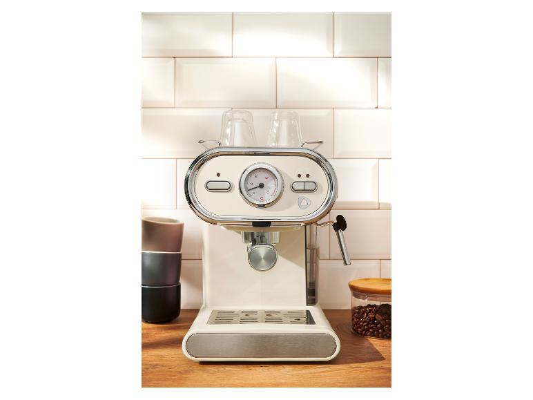 Machine à expresso couleur crème de style rétro sur un comptoir de cuisine en bois.
