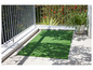 Un tapis d'herbe artificielle verte sur une terrasse avec un pot de fleurs et de l'ombre