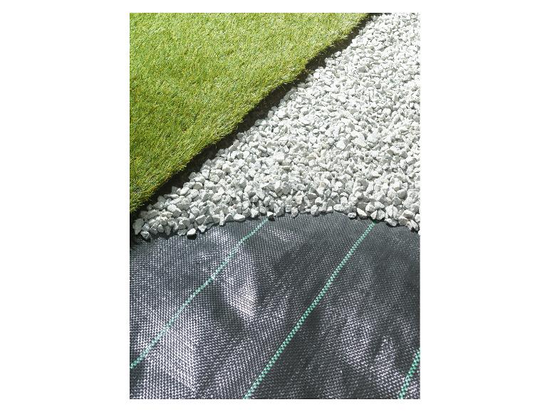 Gazon artificiel, galets blancs et toile de paillage noire.