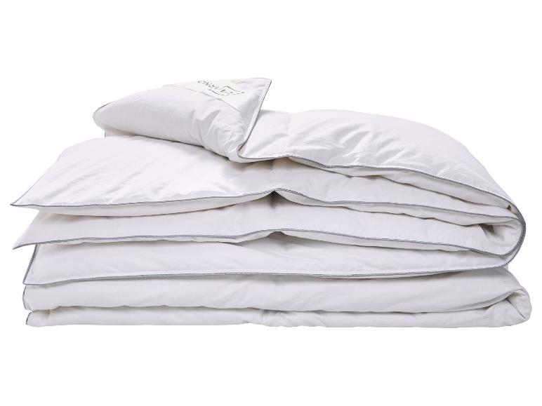 Couette et oreiller blancs avec liseré gris, pliés et empilés.