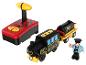 Un train jouet en bois avec une locomotive, un wagon-citerne et une figurine de conducteur.