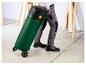 Homme tirant un aspirateur industriel vert à roulettes, avec étiquette 96 dB.