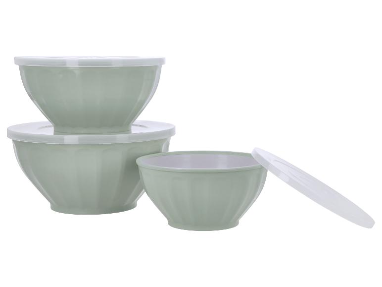 Ensemble de trois saladiers vert clair avec couvercles blancs, empilés et un ouvert.