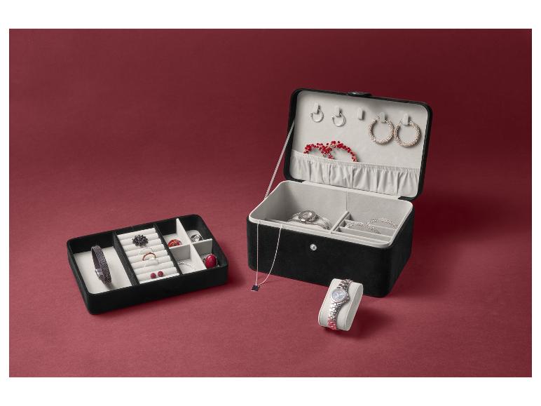 Un coffret à bijoux ouvert avec des boucles d'oreilles, des bracelets et une montre.