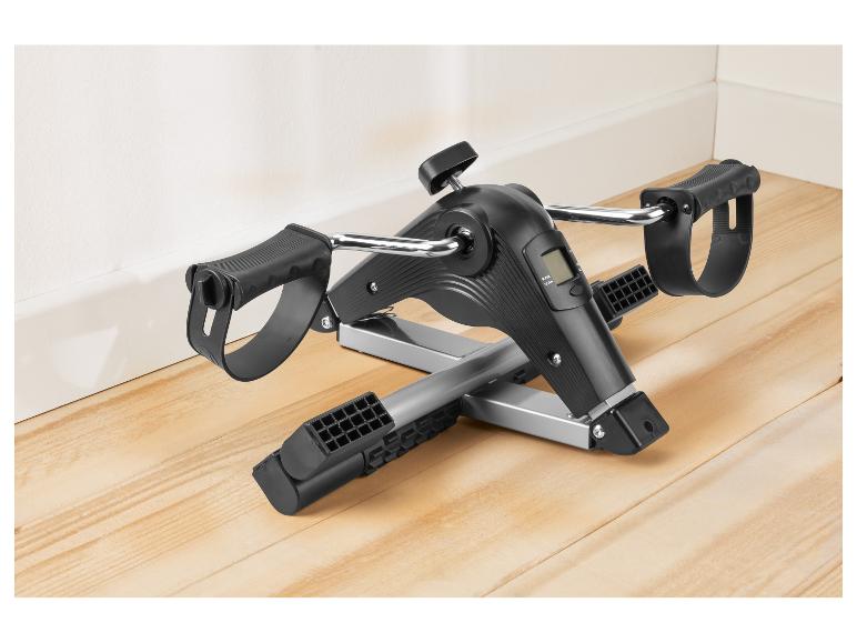 Mini vélo d'exercice noir et argenté avec écran numérique sur un plancher en bois.