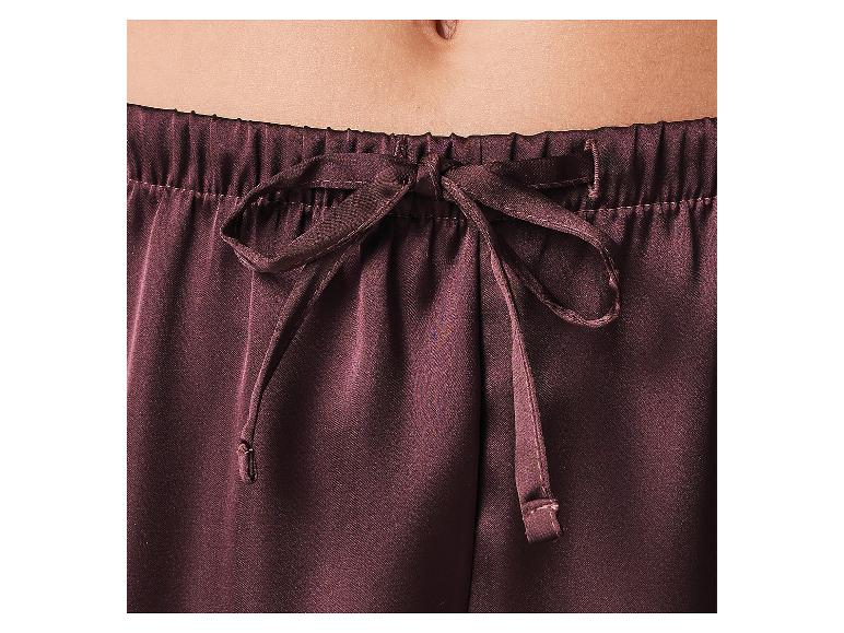 Gros plan d'un ventre et d'un pantalon de pyjama marron foncé avec un cordon de serrage.