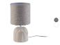 Lampe de table beige avec abat-jour en tissu et base en céramique côtelée.